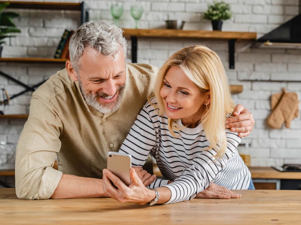 a couple at the counter planning their retirement on their smartphone