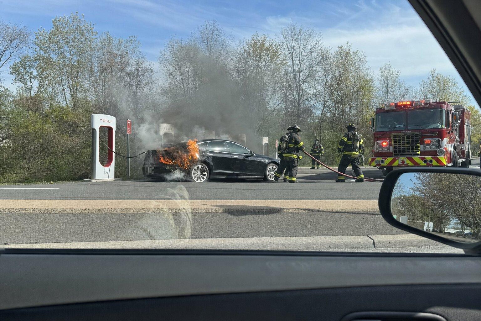 Black Tesla on fire at charging station