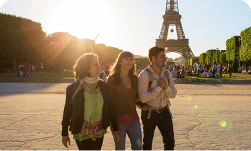 Three travelers walking together with the Eiffel Tower behind them; Unpack Once Collection weeklong tours. Opens Single-City Weeklong Tours hub, EF Go Ahead Tours.