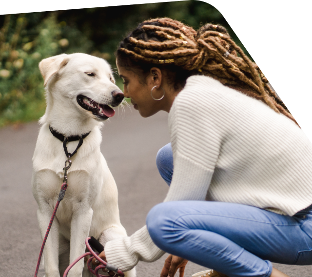Woman kneeling to be fact-to-face with her dog