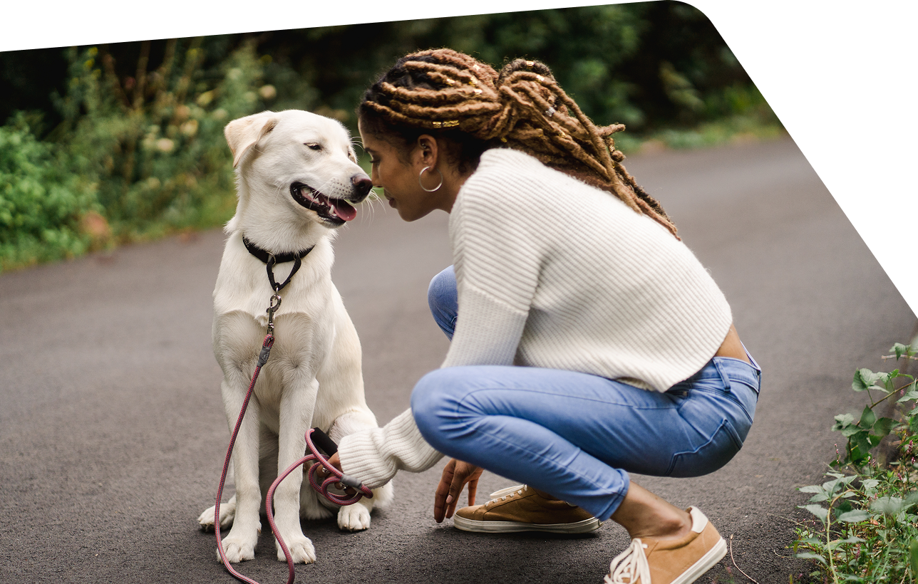 Woman kneeling to be face-to-face with her dog