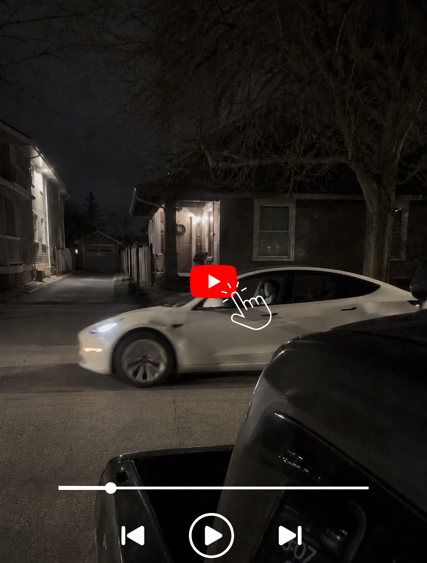 Dark Tesla car on wet street at night