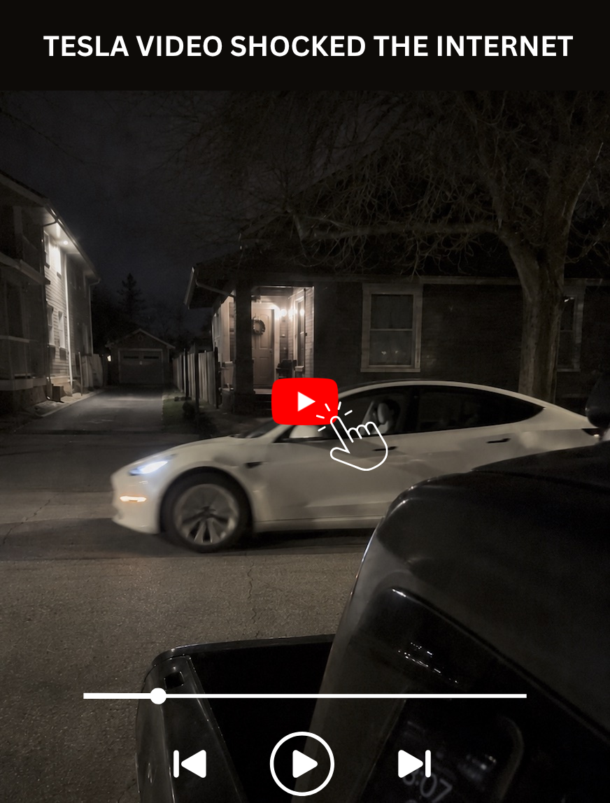 Dark Tesla car on wet street at night