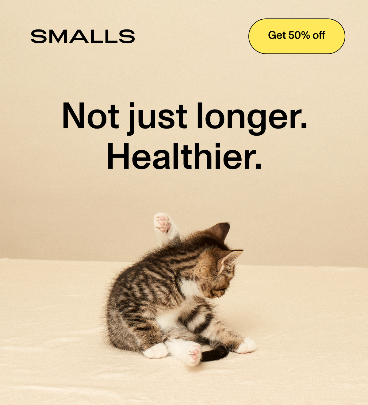 A tabby kitten grooming itself on a soft beige background. Headline reads: Not just longer. Healthier. A Get 50% off button sits in the top right corner next to the Smalls logo.