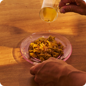 Photo of liquid being poured into a bowl of cat food on a wooden surface