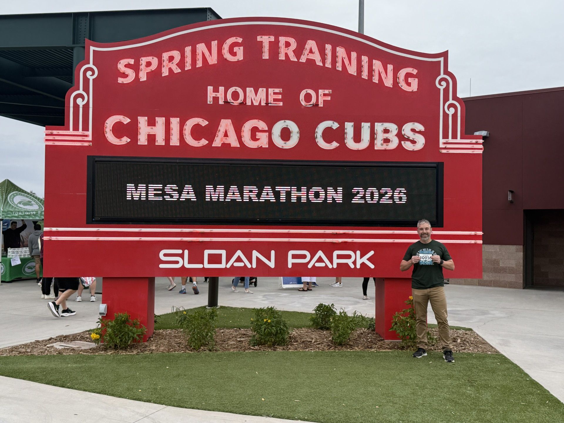 Jordan Bastian in front of Mesa Marathon sign