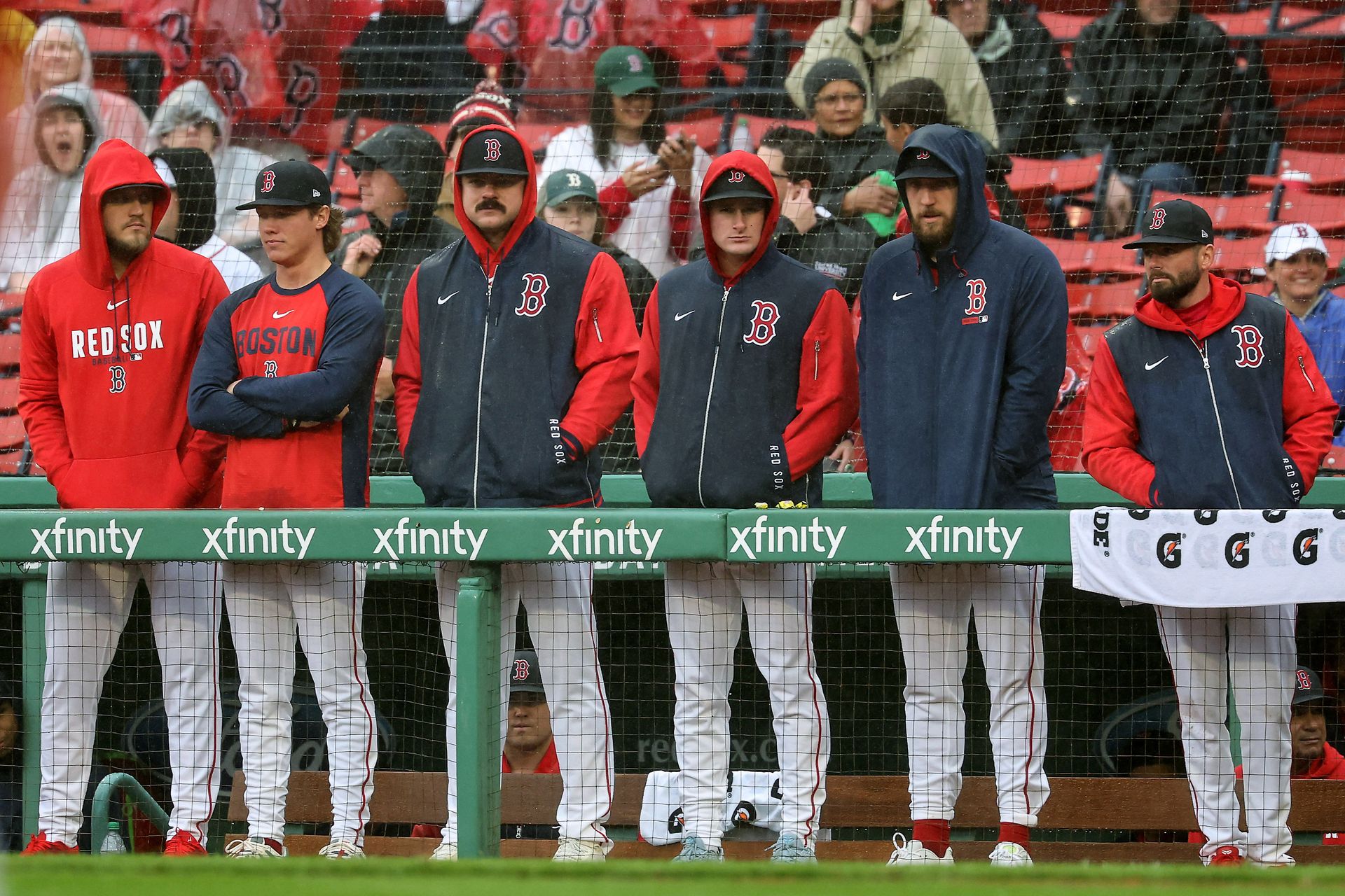 Red Sox players stand in the dugout at Fenway Park