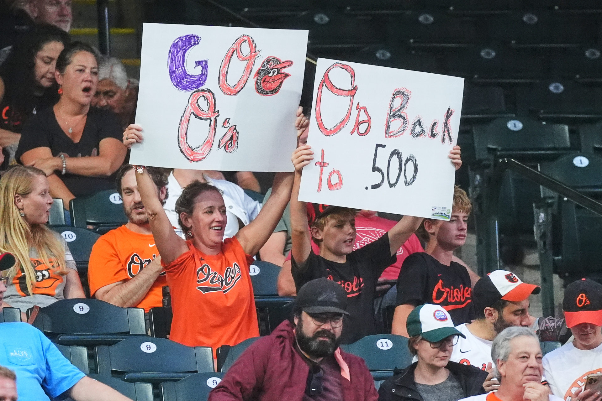 Orioles fans hold up signs in the stands