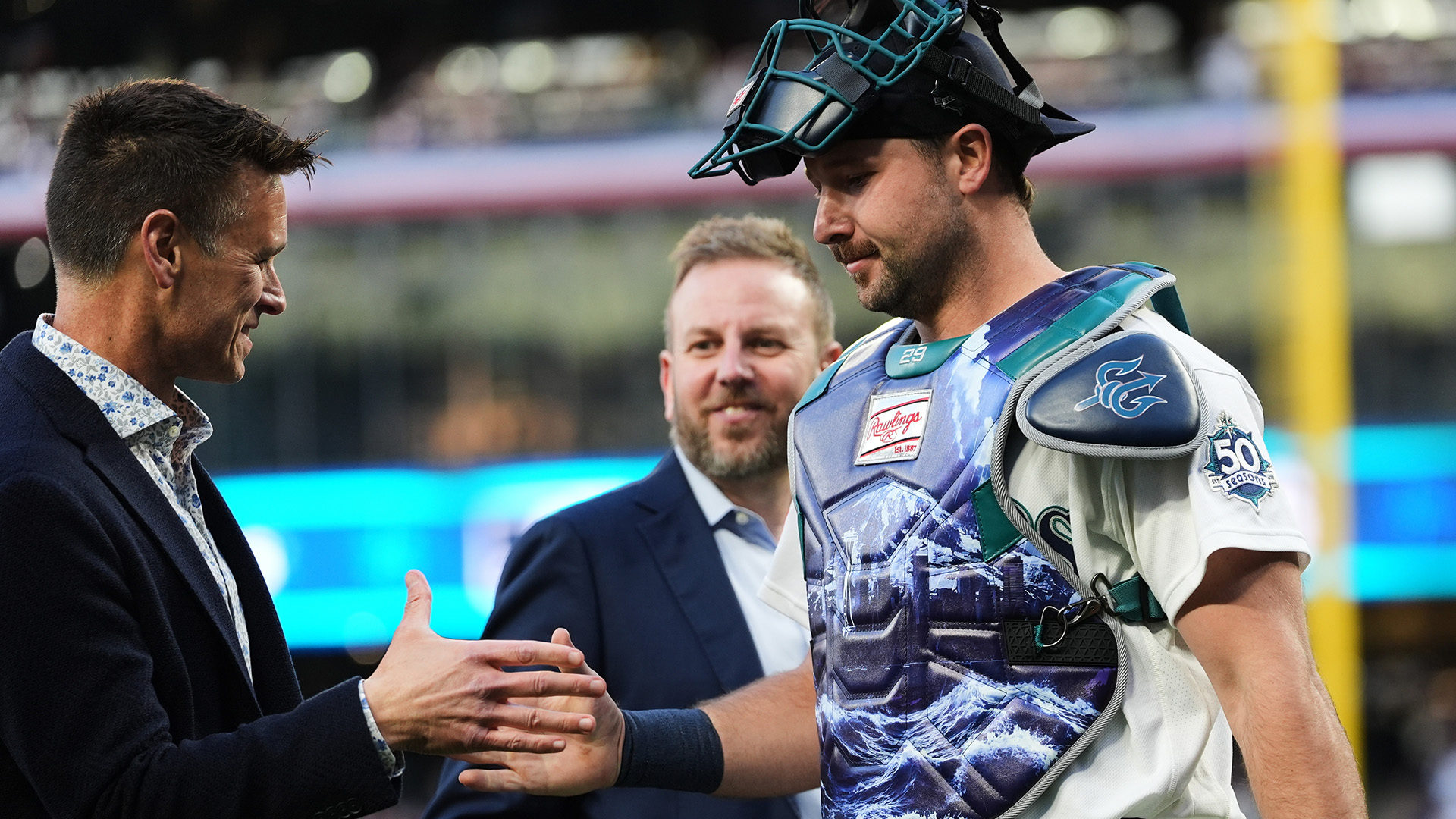 Jerry Dipoto and Justin Hollander with Cal Raleigh