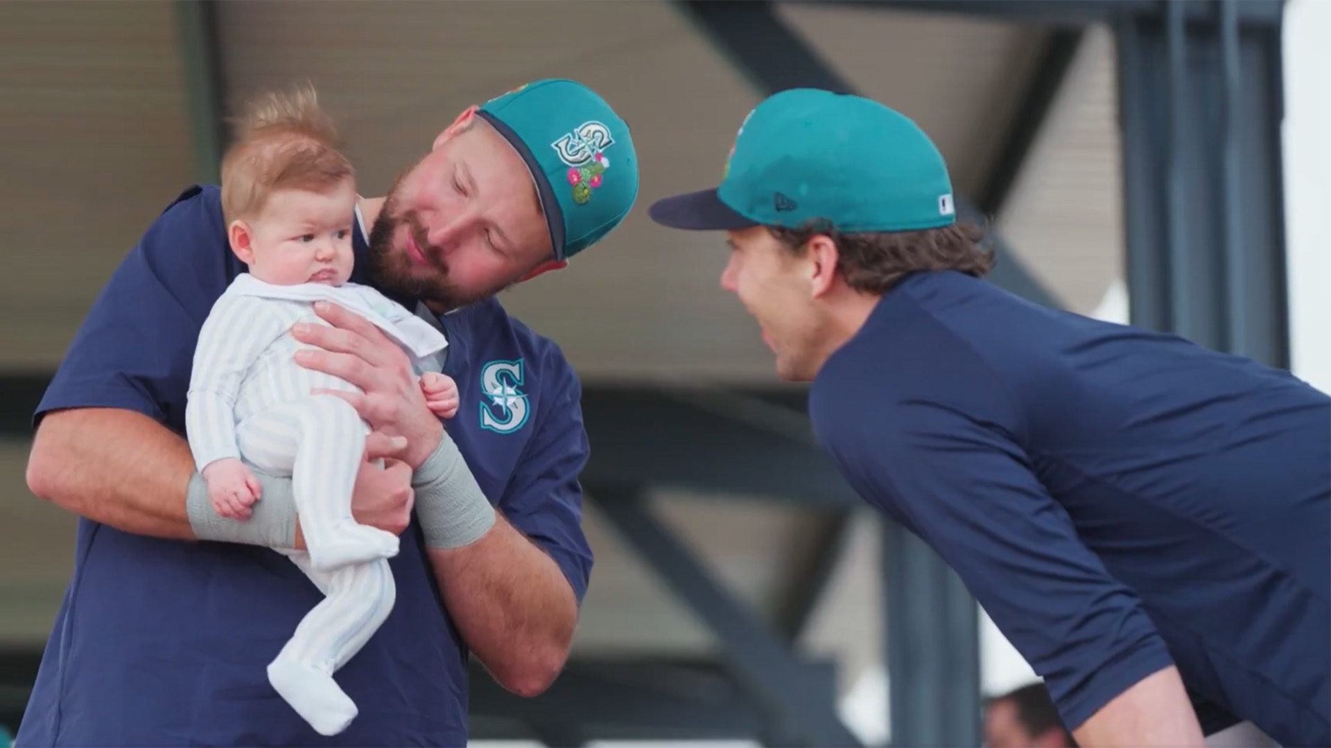 Cal Raleigh holding Logan Gilbert's child, Henry