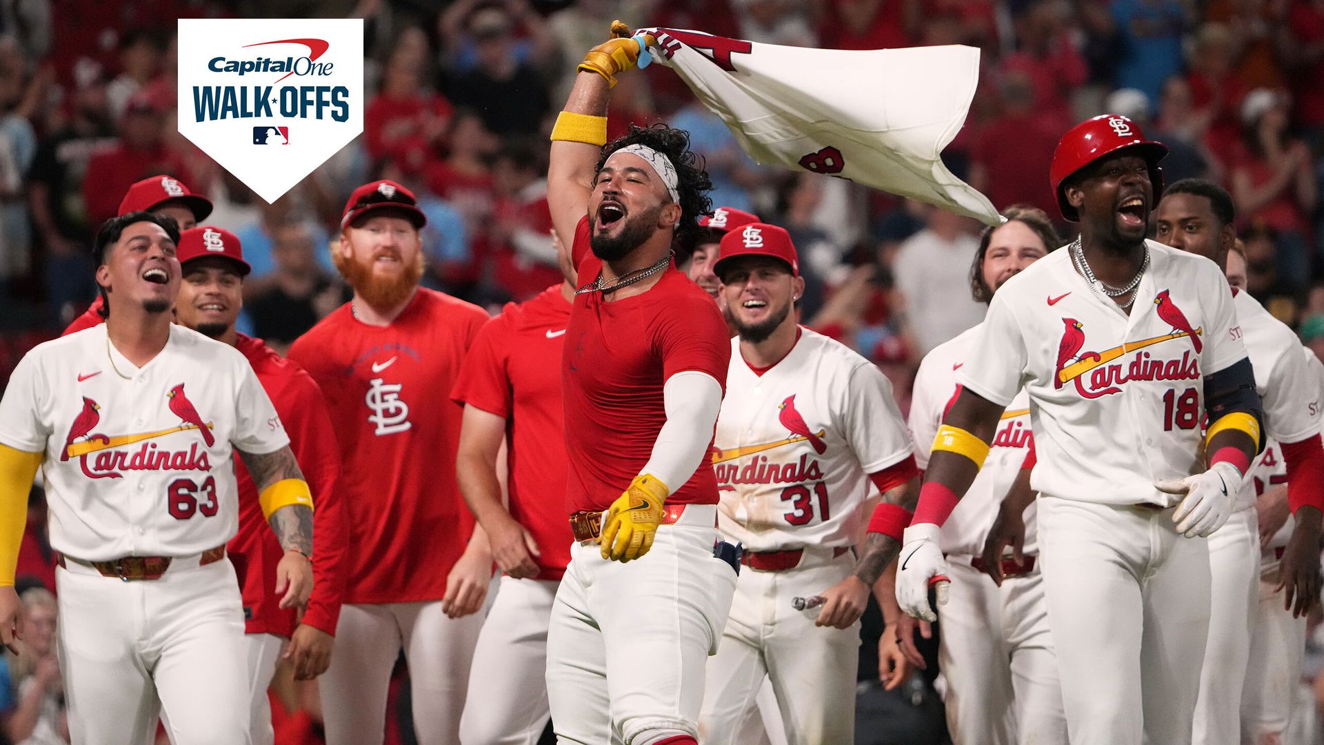 Iván Herrera waves his jersey over his head as the Cardinals celebrate his walk-off home run