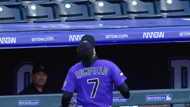 An animated gif of Rockies first baseman TJ Rumfield tumbling into the dugout while making a catch